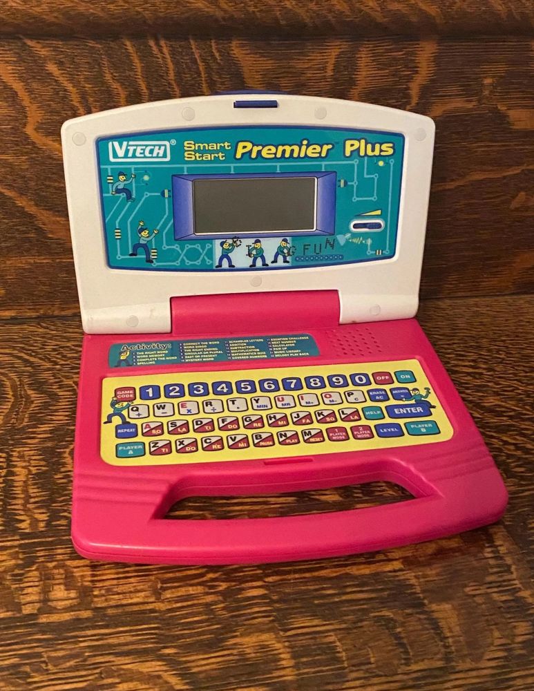 A V-TECH SmartStart Premier Plus children’s learning toy, which looks like a laptop computer with a small 2 inch by 5 inch screen and a flat keyboard. 