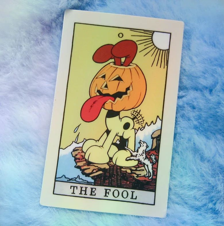 A tarot card sticker on a furry blue background. It's an edit of The Fool, but with Odie wearing a jack-o'-lantern on his head.