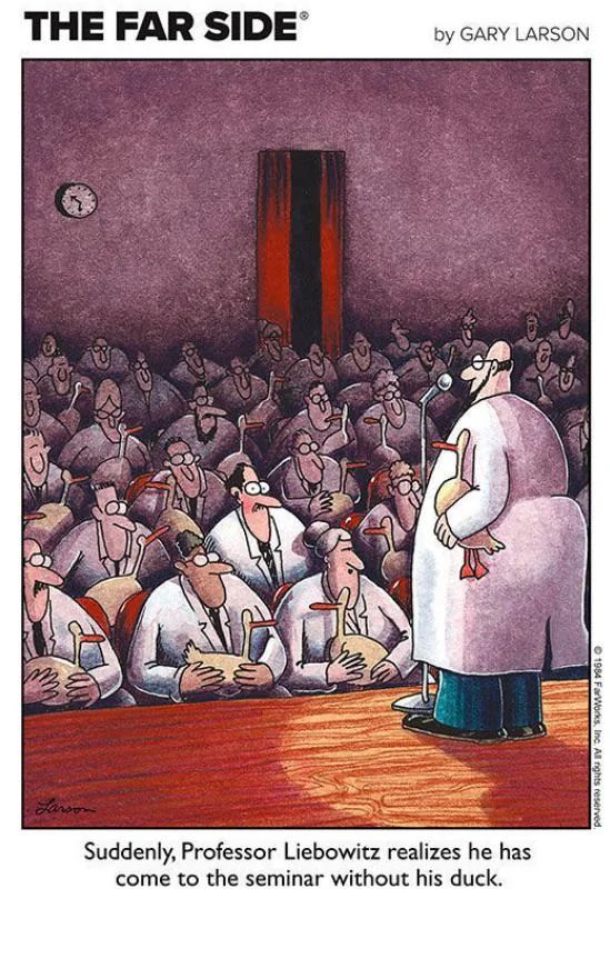 A group of academics in lab coats sitting in a lecture hall. All but one have ducks in their laps. The academic without a duck has his eyes open in terror. The caption reads "Suddenly, Professor Liebowitz realizes he has come to the seminar without his duck."