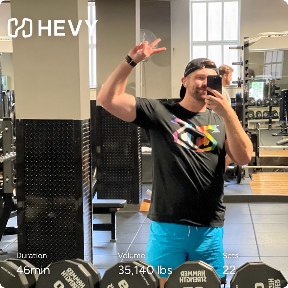 man at the gym with a pride shirt and blue shorts 