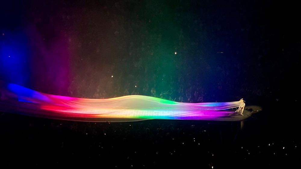 lady gaga with a rainbow-colored flowing dress