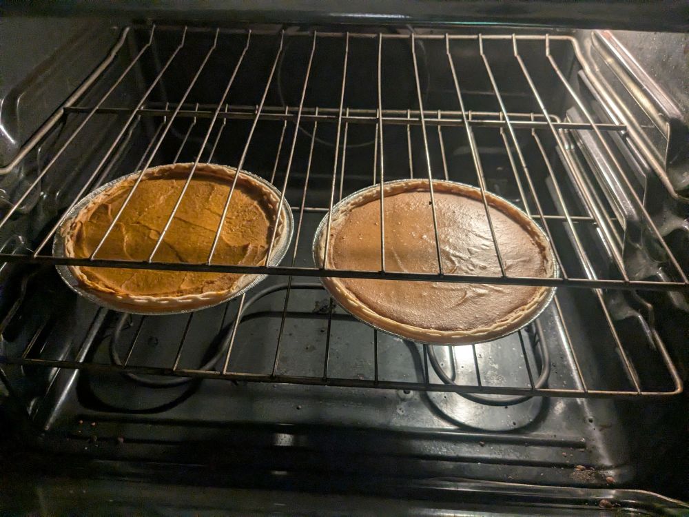 two partially baked fragrant vegan pumpkin pies in the oven