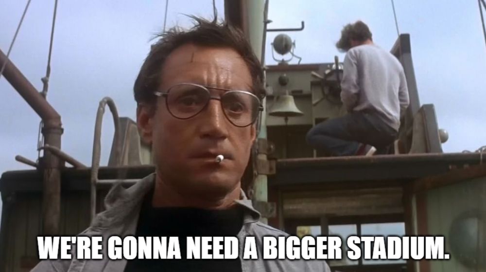 A still from the movie Jaws showing a man in glasses on a boat. The meme caption states "We're gonna need a bigger stadium."