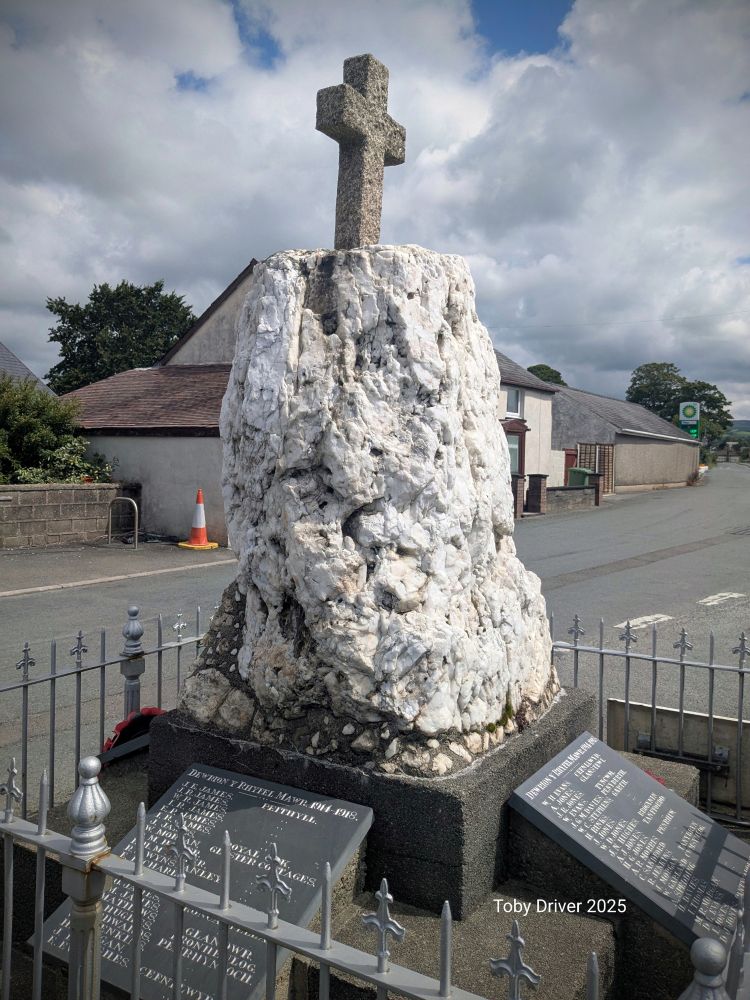 A craggy white monolith now built into a war memorial in a village square 