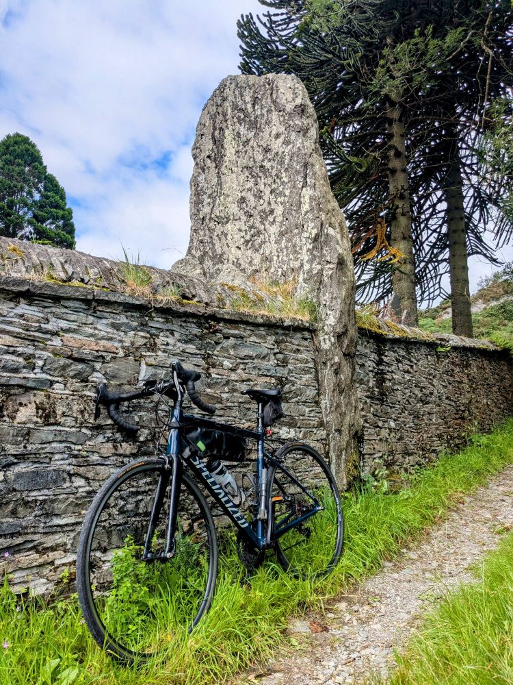Standing stone in a church wall with a bike