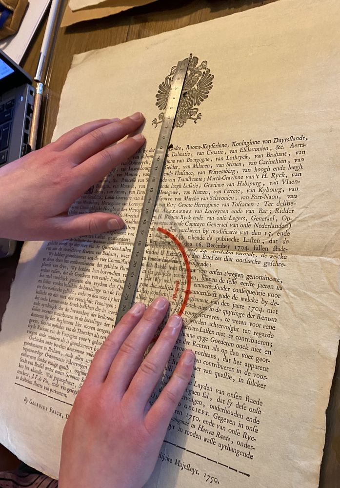 The hands of our intern using a ruler to measure the type area of a broadsheet