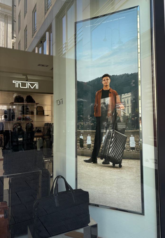 Poster of Lando Norris posing next to a suitcase