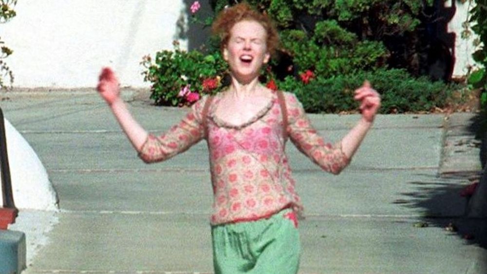 Nicole Kidman wearing a pink top and green pants 