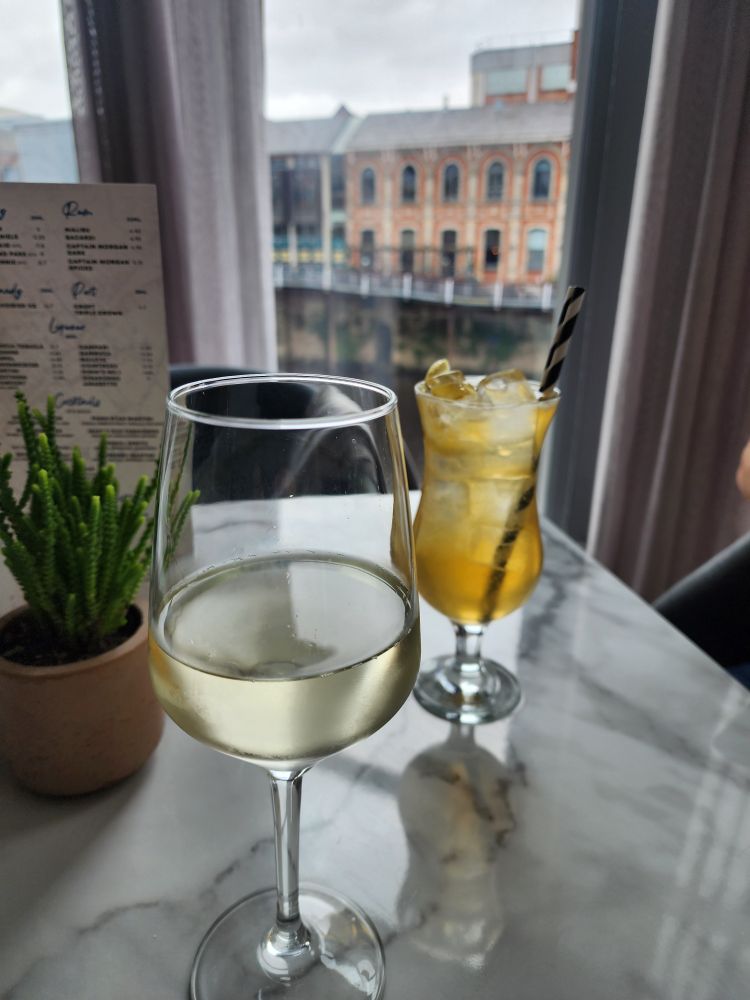 Wine and cocktail with York river in background 
