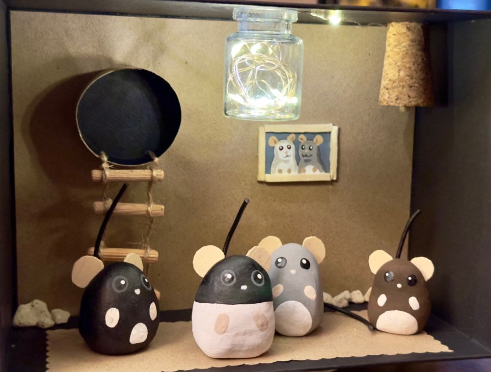 Eine kleine Puppenstube mit 4 kleinen Rattenfiguren (den Ratten der Freundin nachempfunden), mit einem "Rattenbild" der Vorfahren an der Wand.

Inkl. funktionierender Deckenlampe. 