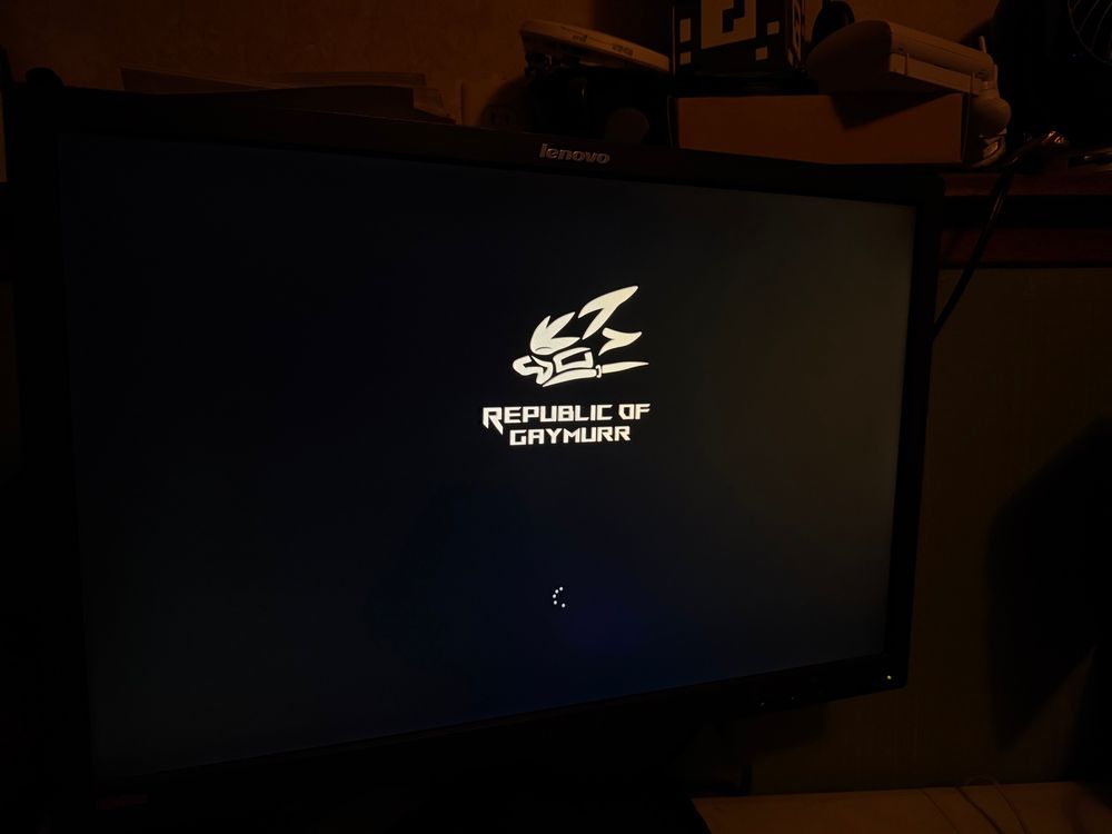 photo of a computer monitor displaying the windows boot screen, the asus republic of gamers logo has been replaced by one that says “republic of gaymurr” with a silhouette of an anthro fox wearing a muzzle harness