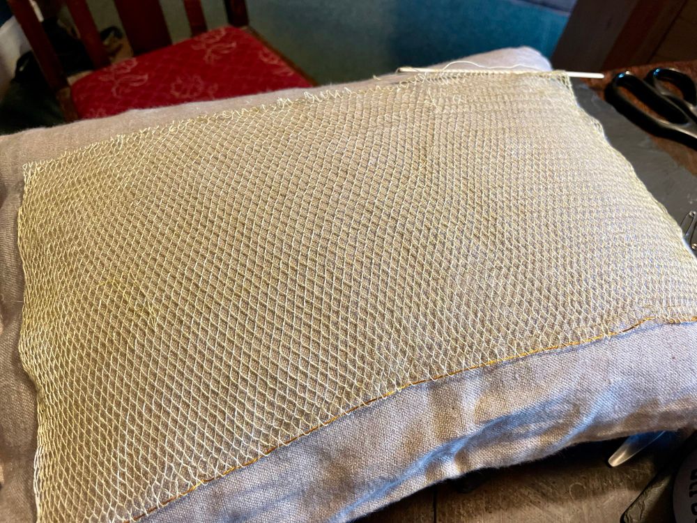 Work in progress on a pale yellow, weld-dyed fine silk mesh hairnet based on extant fragments in the collection of the Museum of Ireland, Dublin.  A flat rectangular shape, headscarf sized textile 