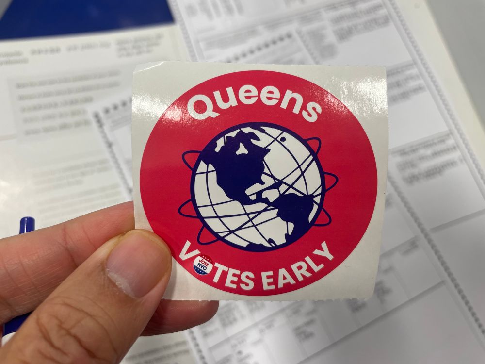 The non-halloween sticker I got for early voting on Sunday (“Queens Votes Early” encircling line drawing of Unisphere)