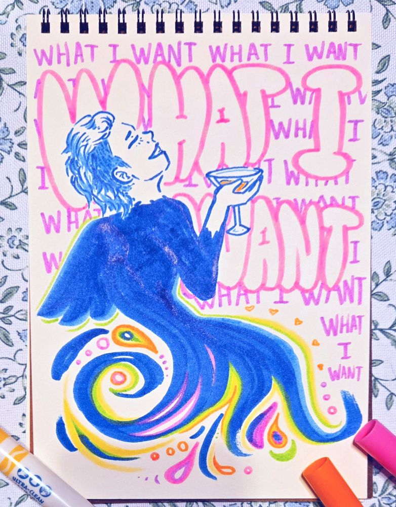 Colorful drawing in a sketchbook of a person with short hair and angel wings smiling with a glass in their hand. In the background the words "What I Want" are written over and over. Crayola markers rest at the corners of the page.