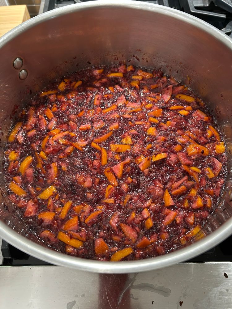 Blood orange marmalade cooking in a pot.