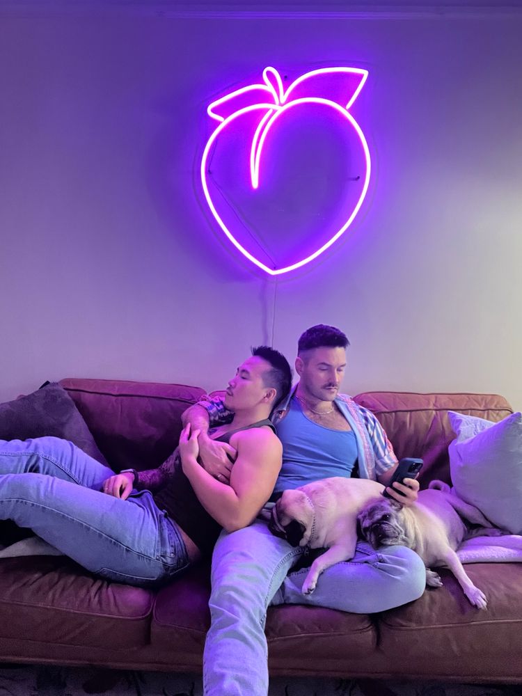 Gay couple chilling on the couch with their 2 pugs