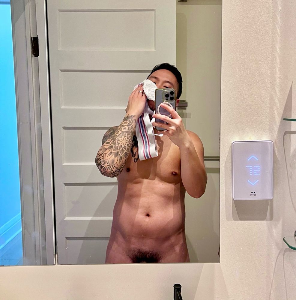 Naked mirror selfie of a man sniffing a dirty jockstrap