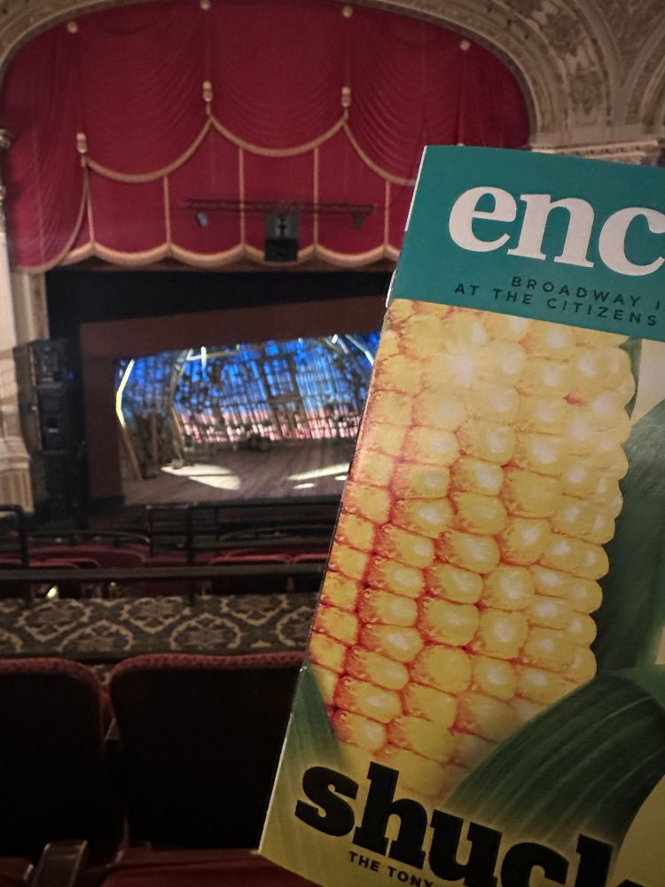 photograph of the encore program for shucked, taken from the mezzanine, with the stage in the background 