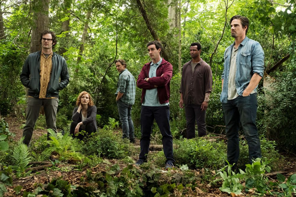 The grown up Losers club stand in the forest looking at something off screen. From the film 'It chapter 2'