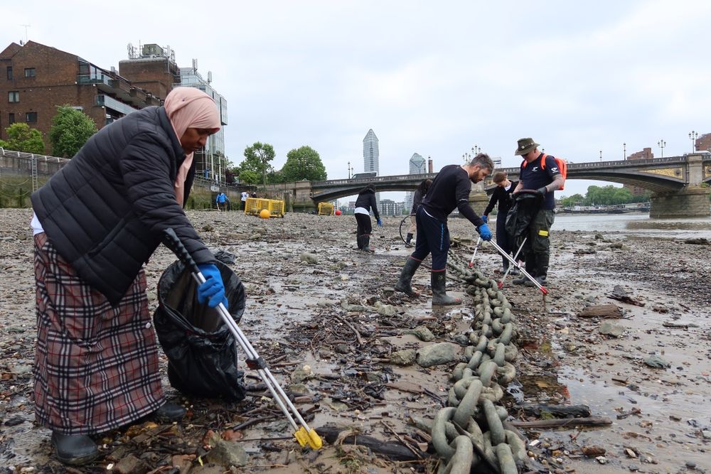 The team at work on the foreshore. The river is tidal here and is at low tide. There is a railway bridge in the background. 