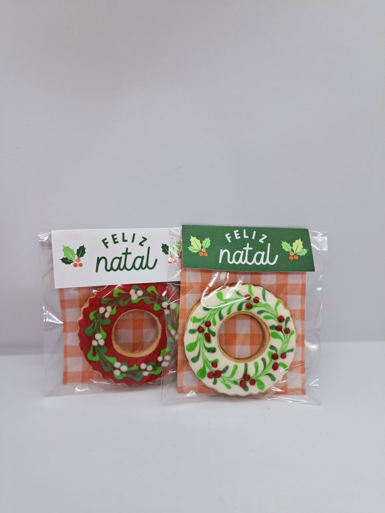dois cartões escrito "feliz natal", cada um com um biscoito decorado de guirlanda
