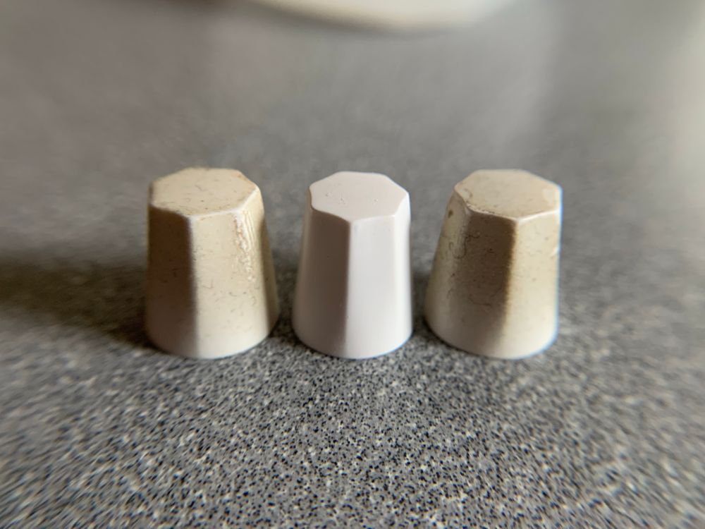 3 knobs from the Arturia Microfreak synthesizer, 2 of them with obvious finger-grease buildup and 1 of them sparkling clean. 