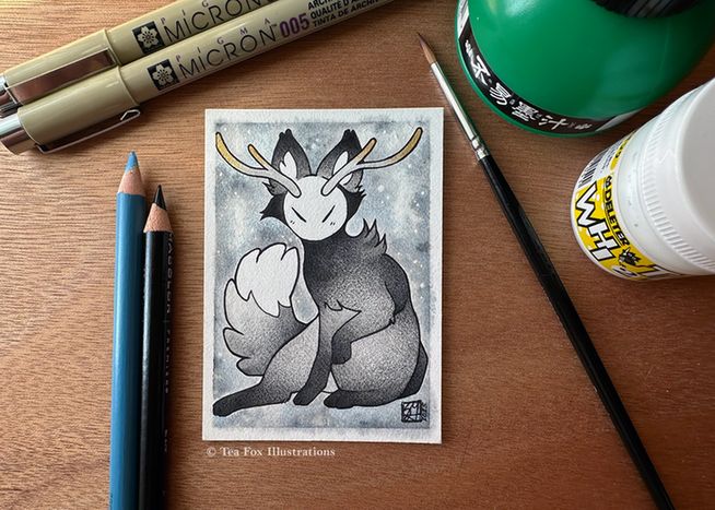 Image shows an art card depicting a fictitious animal spirit with the body similar to a fox, an abstract face like the moon, and antlers tipped with gold. The work surrounded by the materials used to create it, which includes: sumi ink, micron pen, colored pencils, and white ink. 