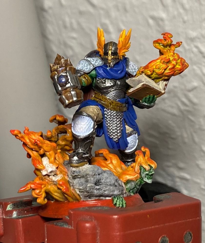 A photo of a Dungeons and Dragons miniature, showing a cleric in full armor and armed with a hammer
