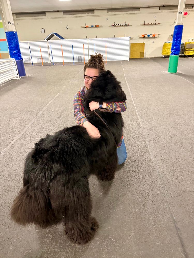 I am wearing a plaid flannel shirt while hugging my 2 year old Newfoundland dog. Only his back is visible. He’s 140 lbs. 
