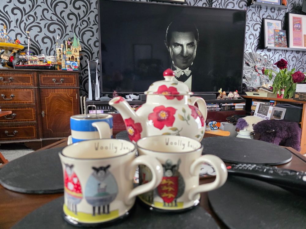 Picture of teapot and teacups with dracula on TV in the background