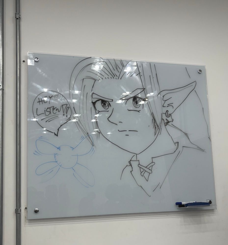 Desenho do personagem link do jogo the legend of Zelda desenhado em quadro branco. Ainda há um desenho da personagem Navi ao lado dele com um balão de diálogo com os dizeres “hey listen” 