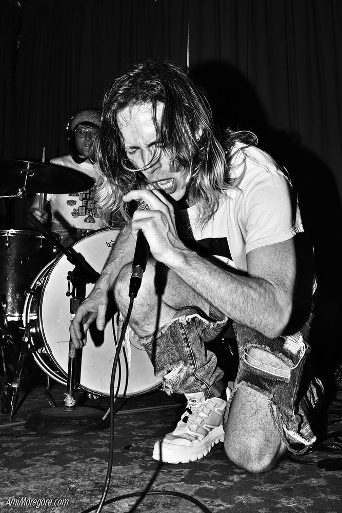 Coco Joey kneels and growls into the mic while Trust Fund Ozu plays drums in the background