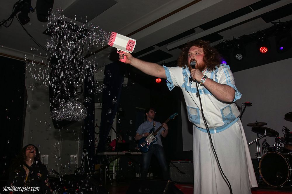 Ultradeluxe performing with their vocalist shooting bubbles out of a bubble gun