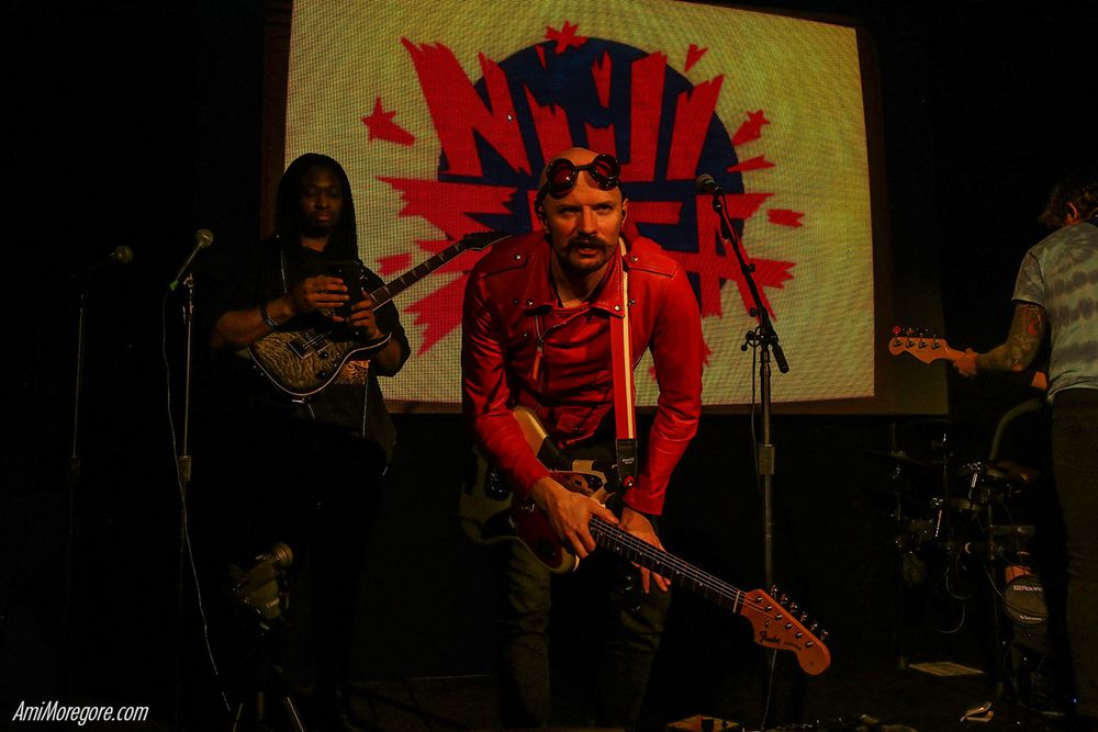 Part of the band Niji Saga on stage looking forward