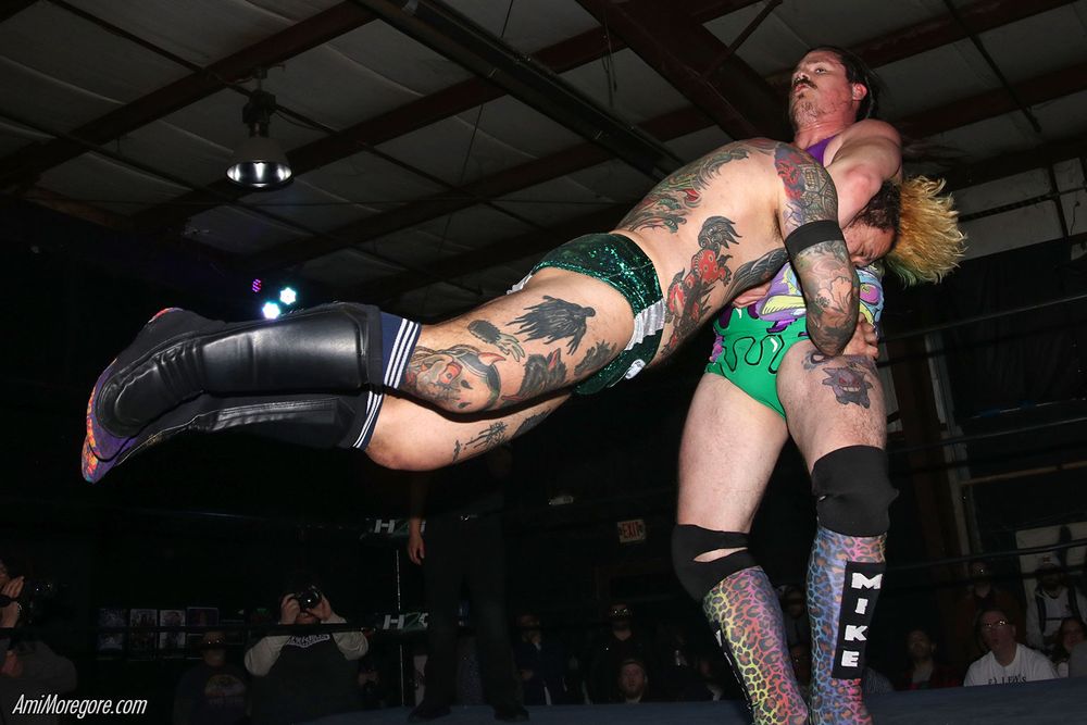 Wrestler White Mike spins Kevin Ku around by the neck in a move called the yam opener