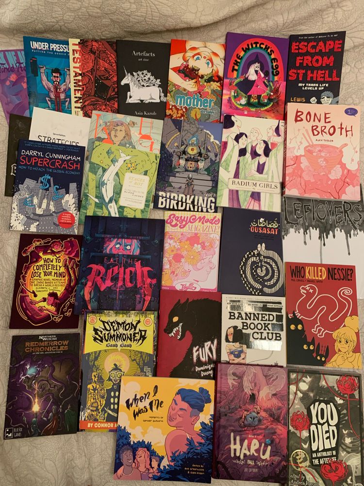 A photo of various comics laid out on a blanket. 