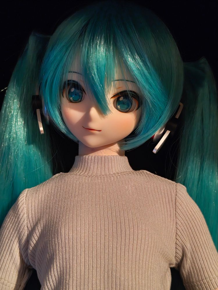 Close-up of the Miku doll in her new grey jumper