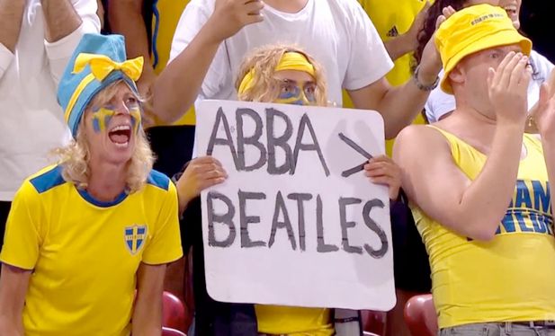 A Swedish footbal fan holding up a sign that says "Abba > Beatles" at the England vs Sweden at the Woman's Euro 2025 quarterfinals