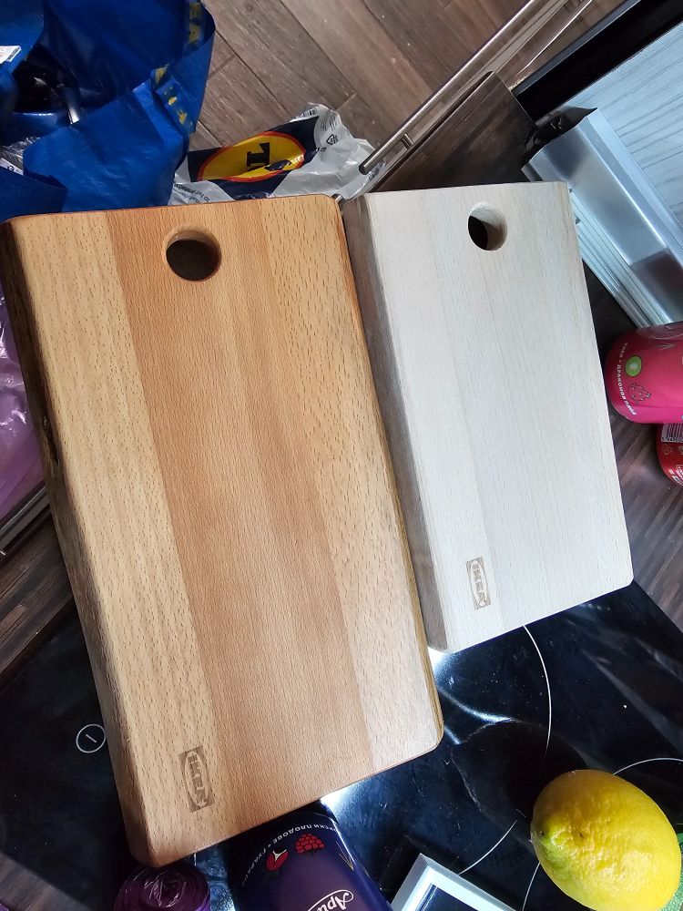 Two new wooden cutting boards, side by side, one oiled and the other not, showing the difference in color. 