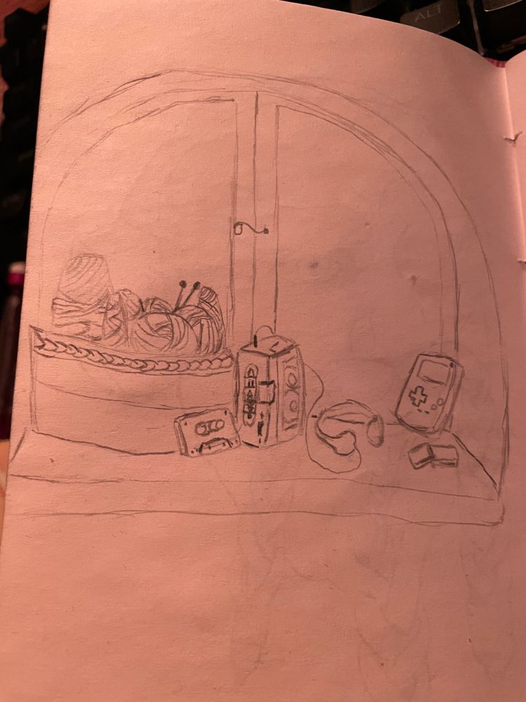 From left to right: a basket full of knitting/crochet supplies, a cassette, a cassette player with headphones plugged in, and a game boy with a few game cartridges in front of it. All of these nestled onto the shelf of a large bay window.