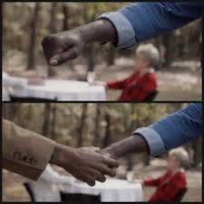 Two screenshots from the film Get Out where one black guy is extending and arm to fist bump another guy but gets his fist shaken instead.