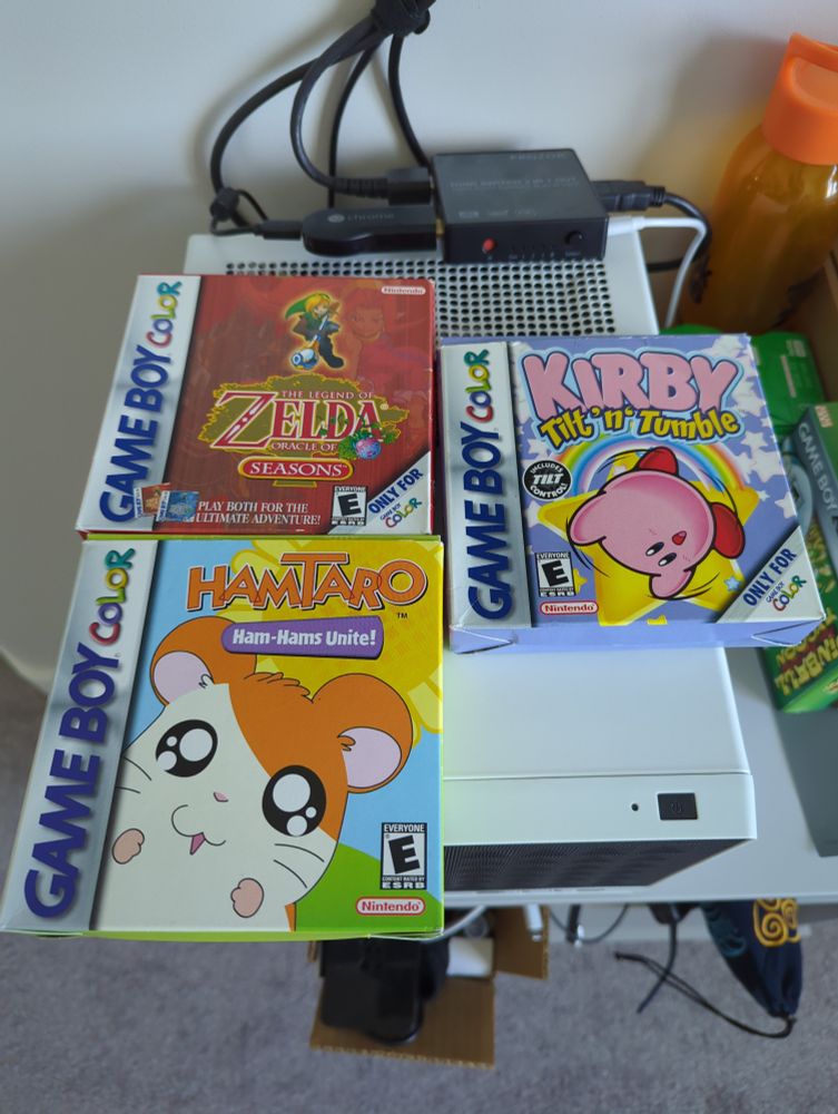 A picture of three Gameboy color game boxes. Including Zelda oracle of seasons, Kirby tilt n' tumble, and hamtaro ham-hams unite