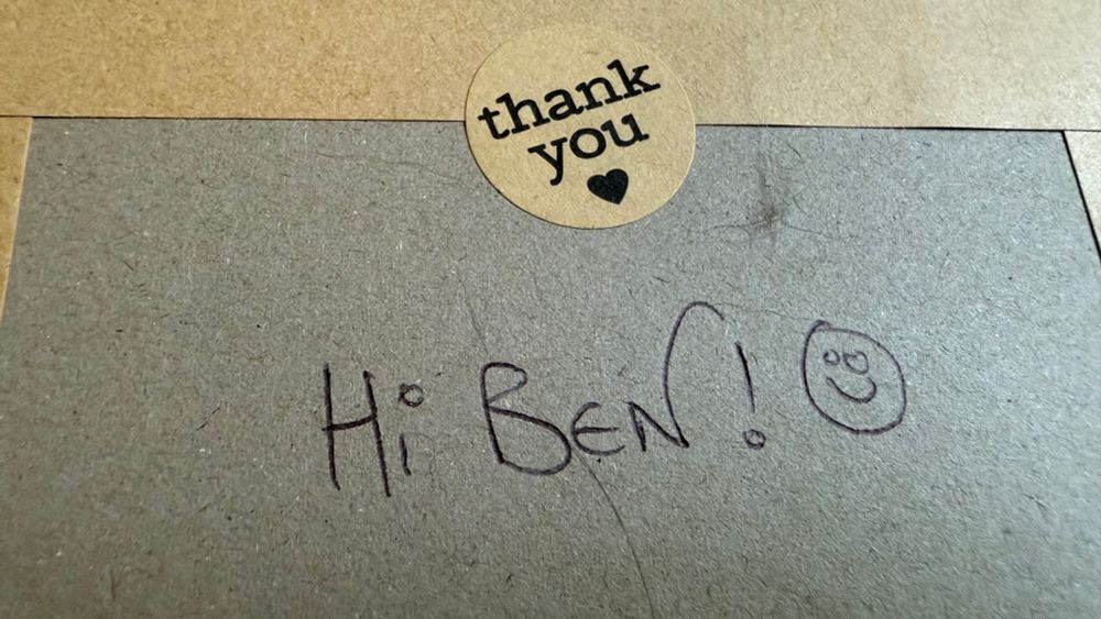 The rear of the envelope containing a Freeze 64 magazine, with a thank You sticker and hand written message saying Hi Ben, with  cute smiley face next to it
