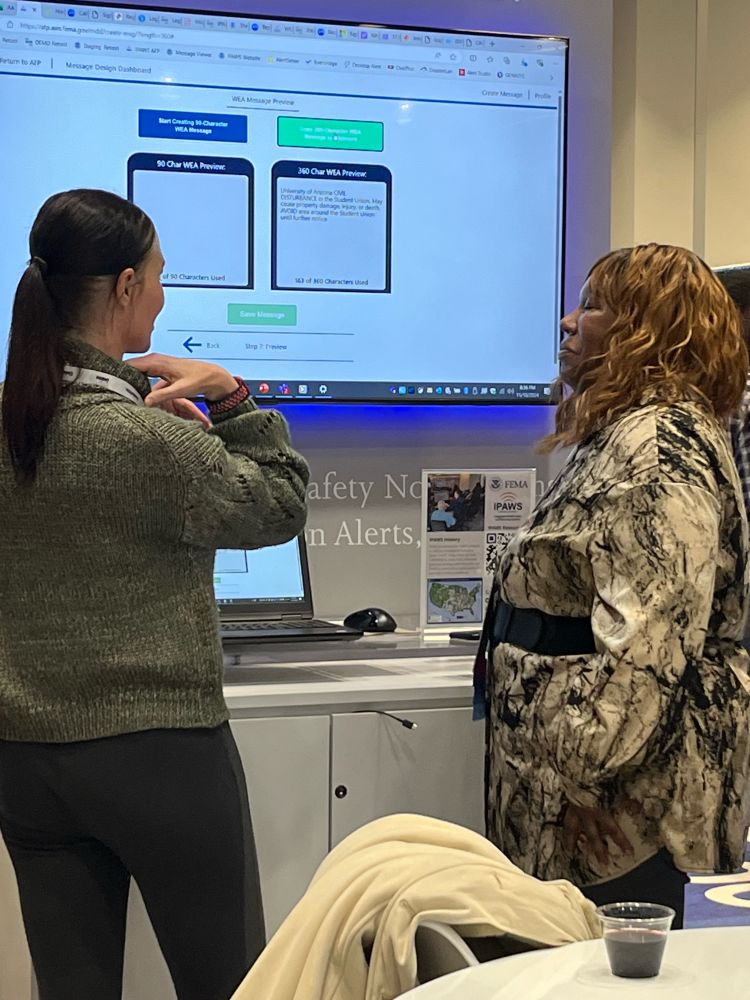 An IPAWS employee teaching about the Message Design Dashboard in the IPAWS booth. 