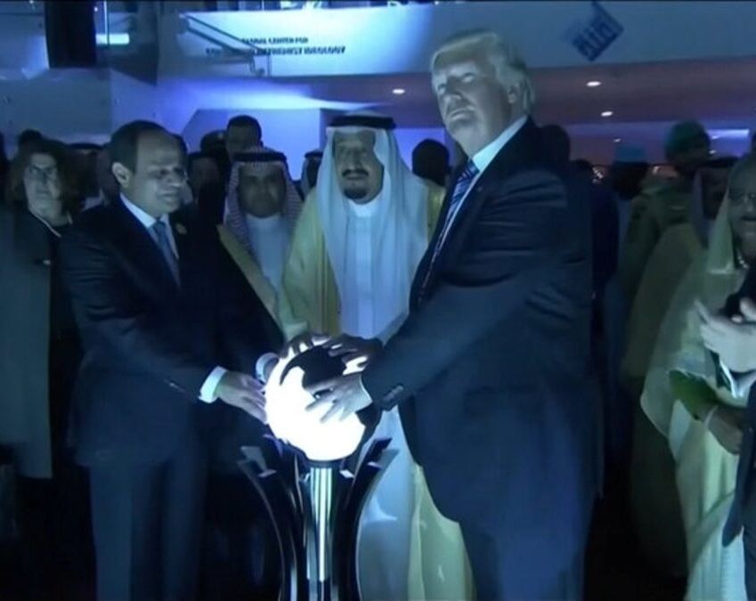 Trump touching a glowing orb.