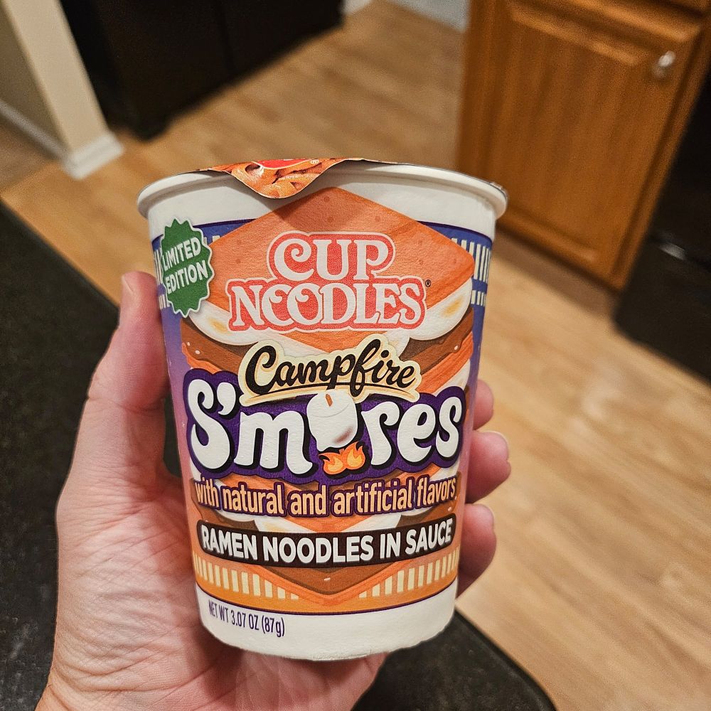 A Cup noodles ramen cup that is listed as "Campfire S'mores" 
