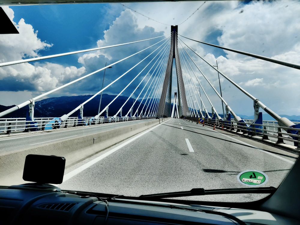 Blick aus dem Womo auf die Fahrbahn und die schrägen Tragseile einer Hängebrücke. 