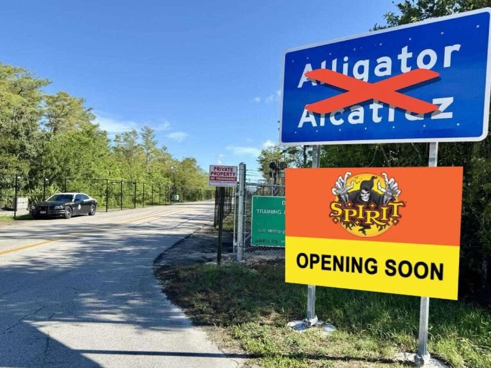 Alligator Alcatraz sign crossed out. Under it, a sign stating Spirit Halloween Opening Soon