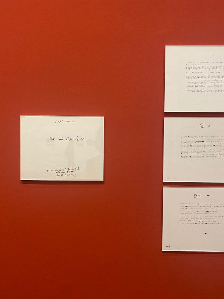 the first pages of “The Arab Apocalypse” mounted on a red wall