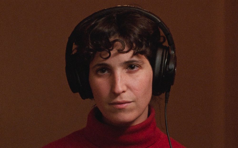 Primer plano de una mujer con unos auriculares. Fotograma de 'La nostra habitació'.